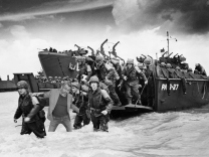 American reinforcements, arrive on the beaches of Normandy from a Coast Guard landing barge into the surf on the French coast on June 23, 1944. They will reinforce fighting units that secured the Norman beachhead and spread north toward Cherbourg.